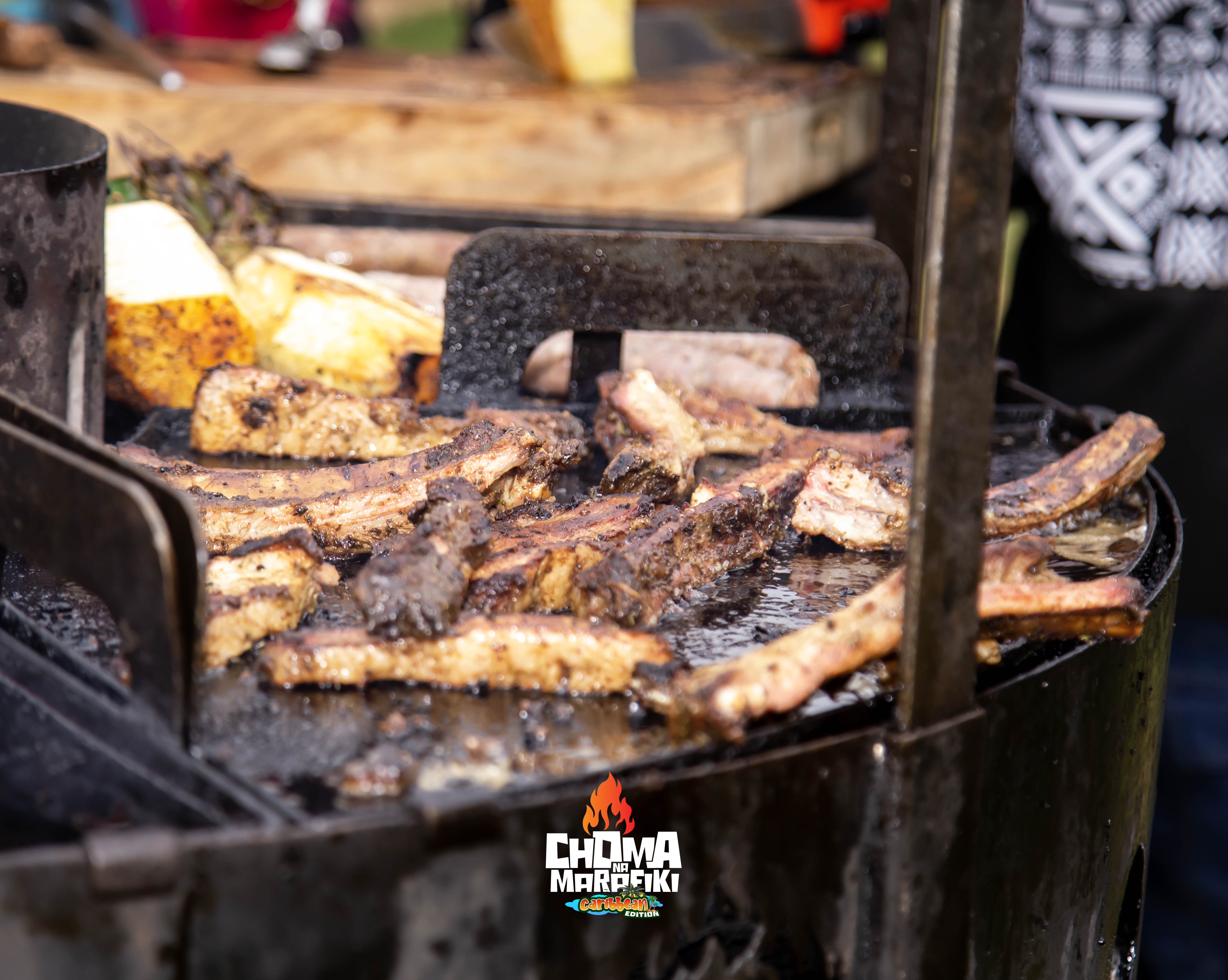 Jerk BBQ ribs and meat grilling on drum grill with pineapple