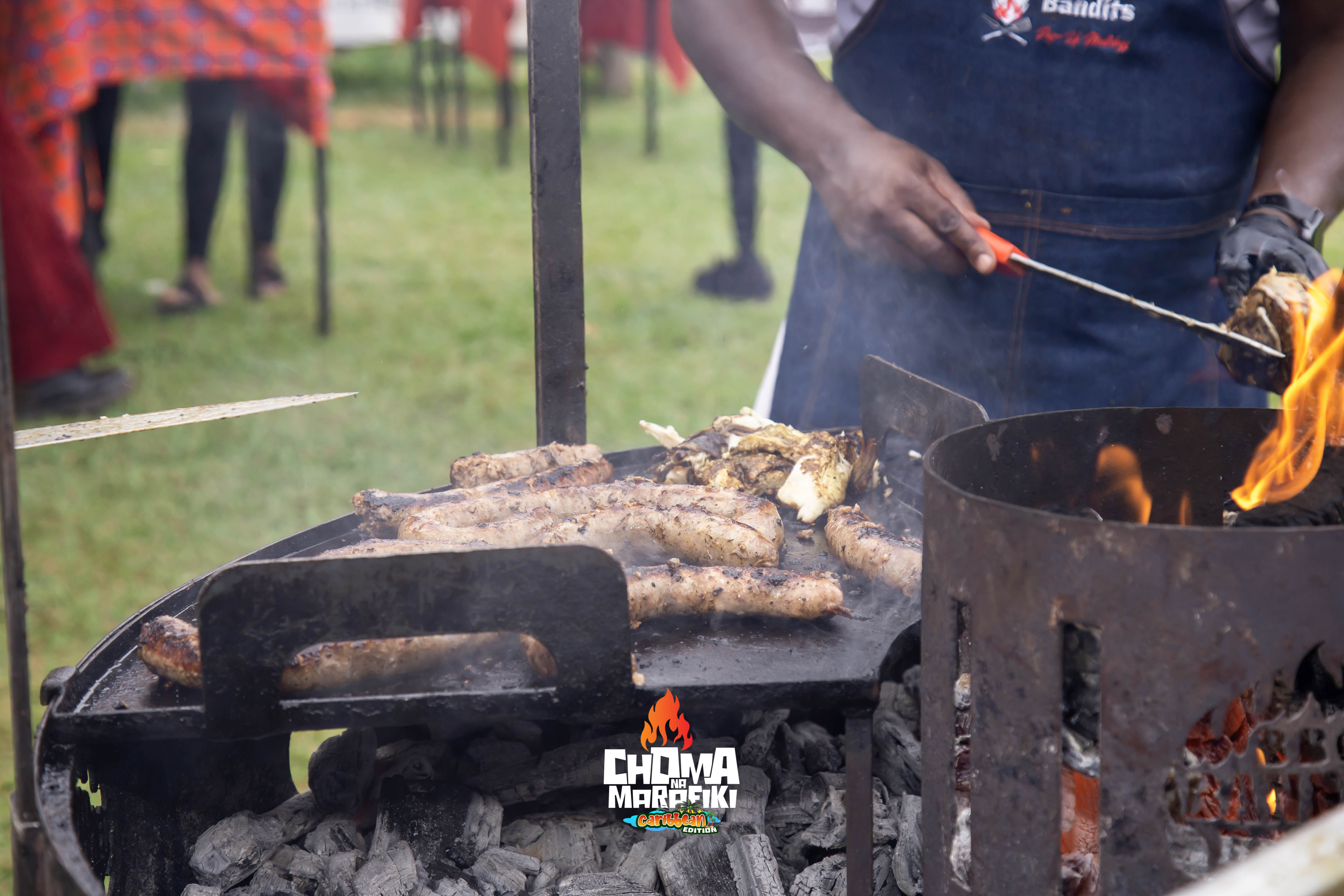 BBQ sausages and meat grilling over open fire at Choma Na Marafiki
